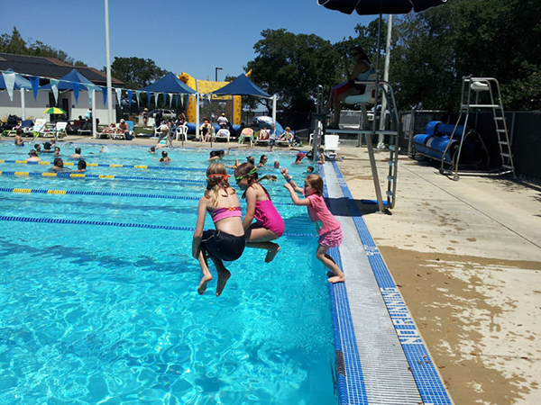 Young girls jumping into pool