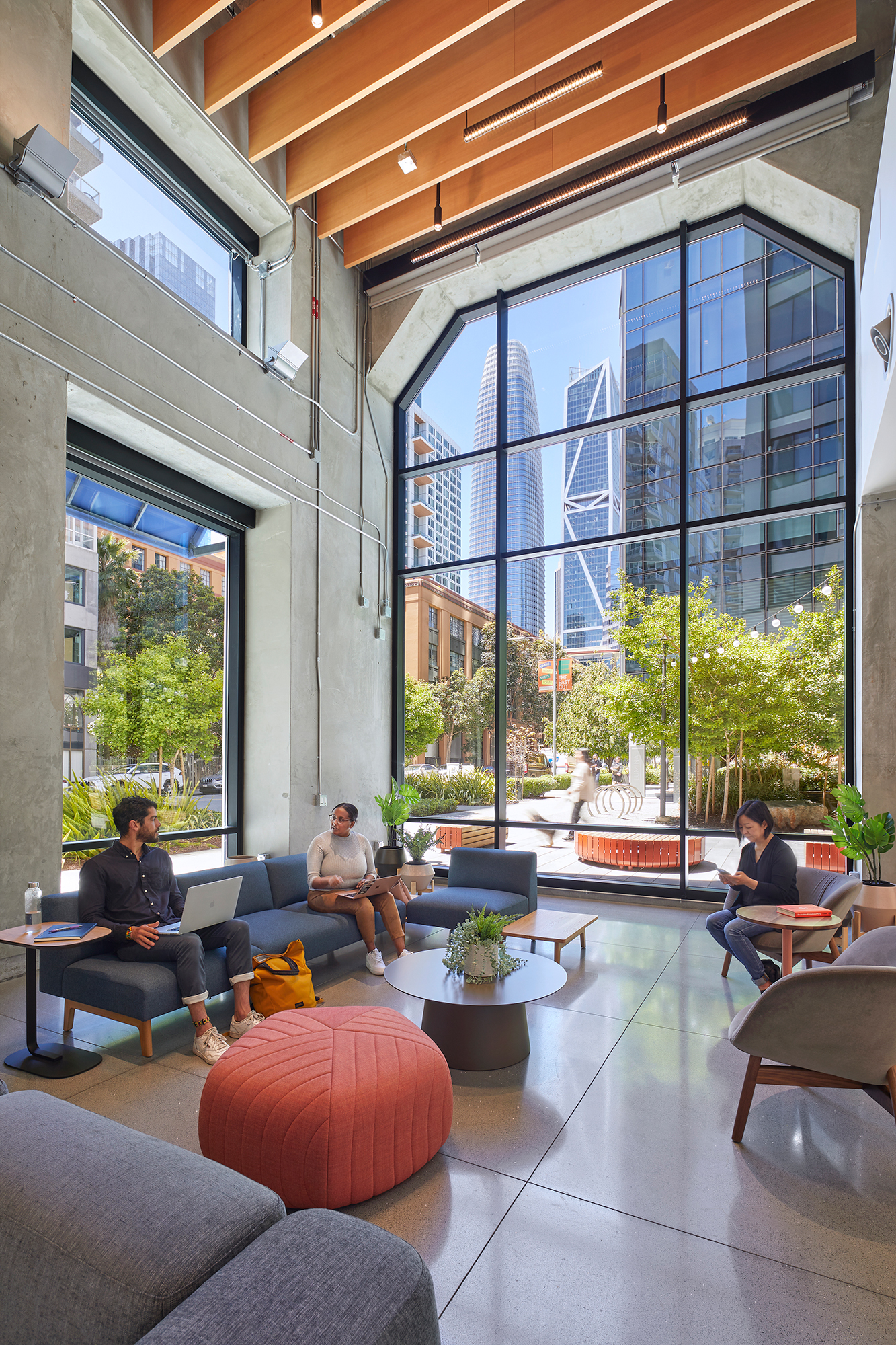 Collaborative lounge space with seating and large windows overlooking the city.