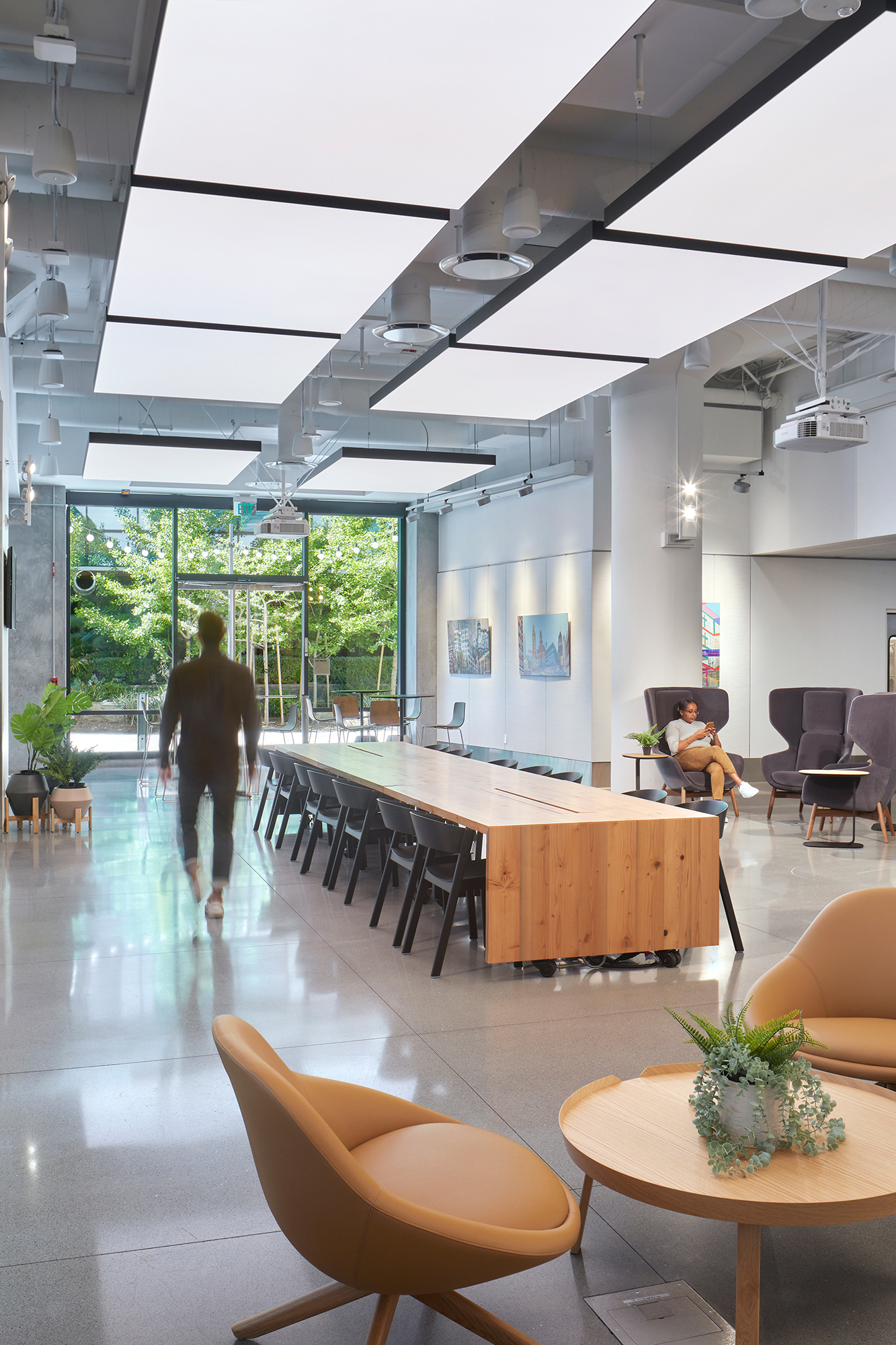 Open space with communal table, lounge seating, and soft lighting.