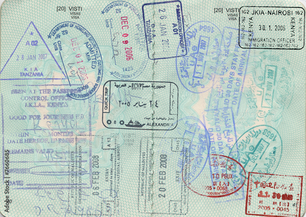 Overlapping international passport stamps and visa markings in multiple colors and languages fill an open passport page.