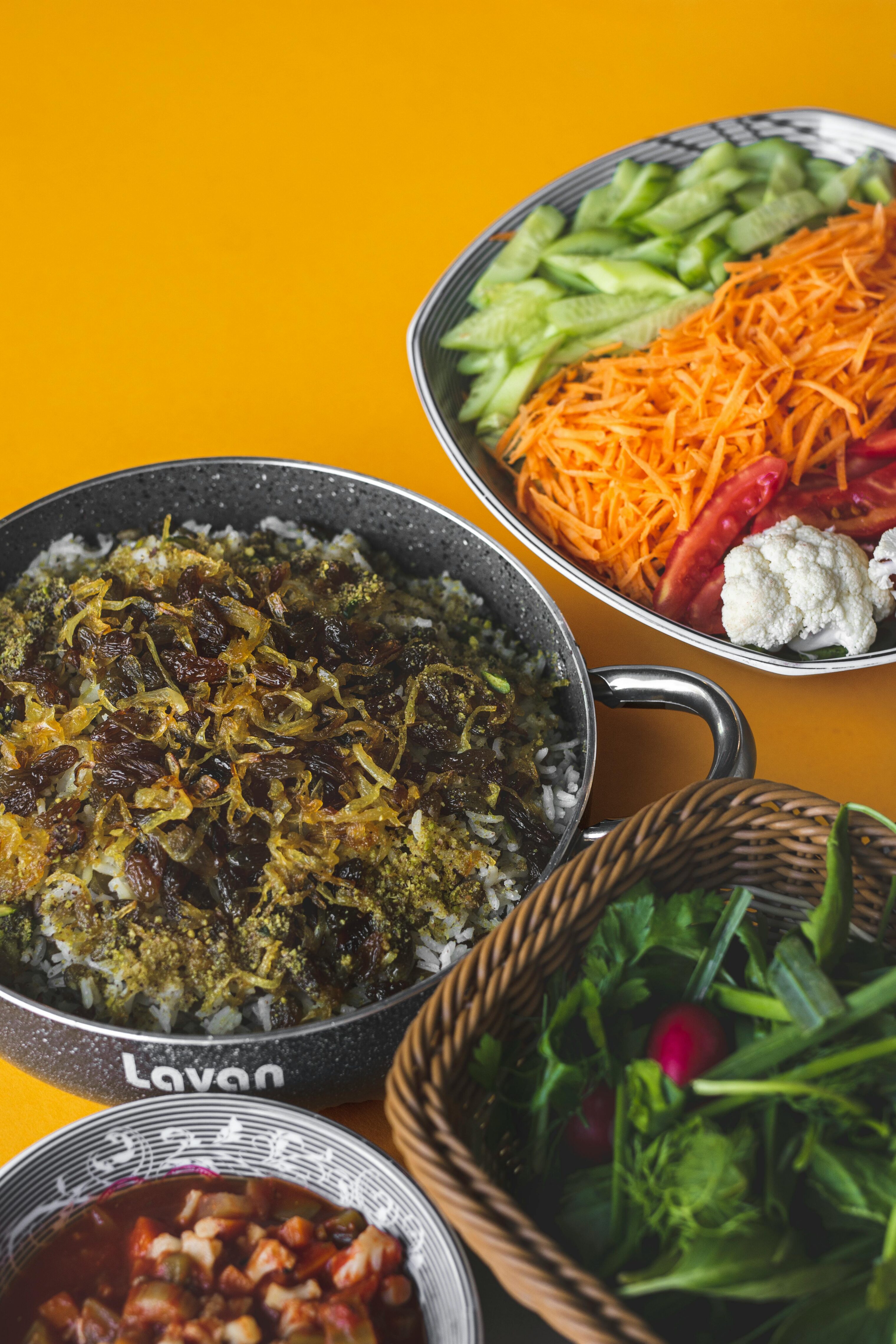 A colorful spread of Iranian food spread on an orange table