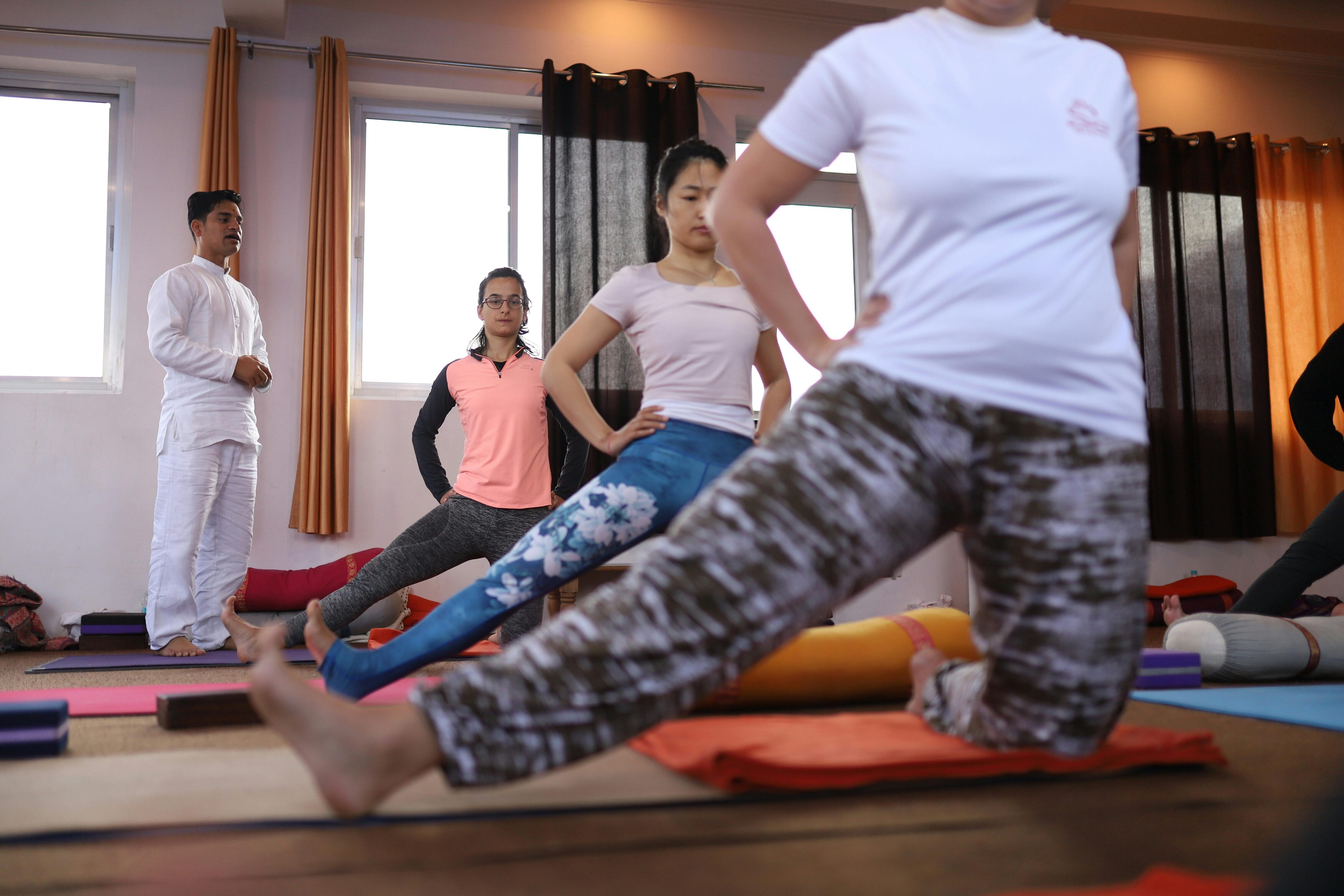 People gathered doing yoga indoors with an instructor