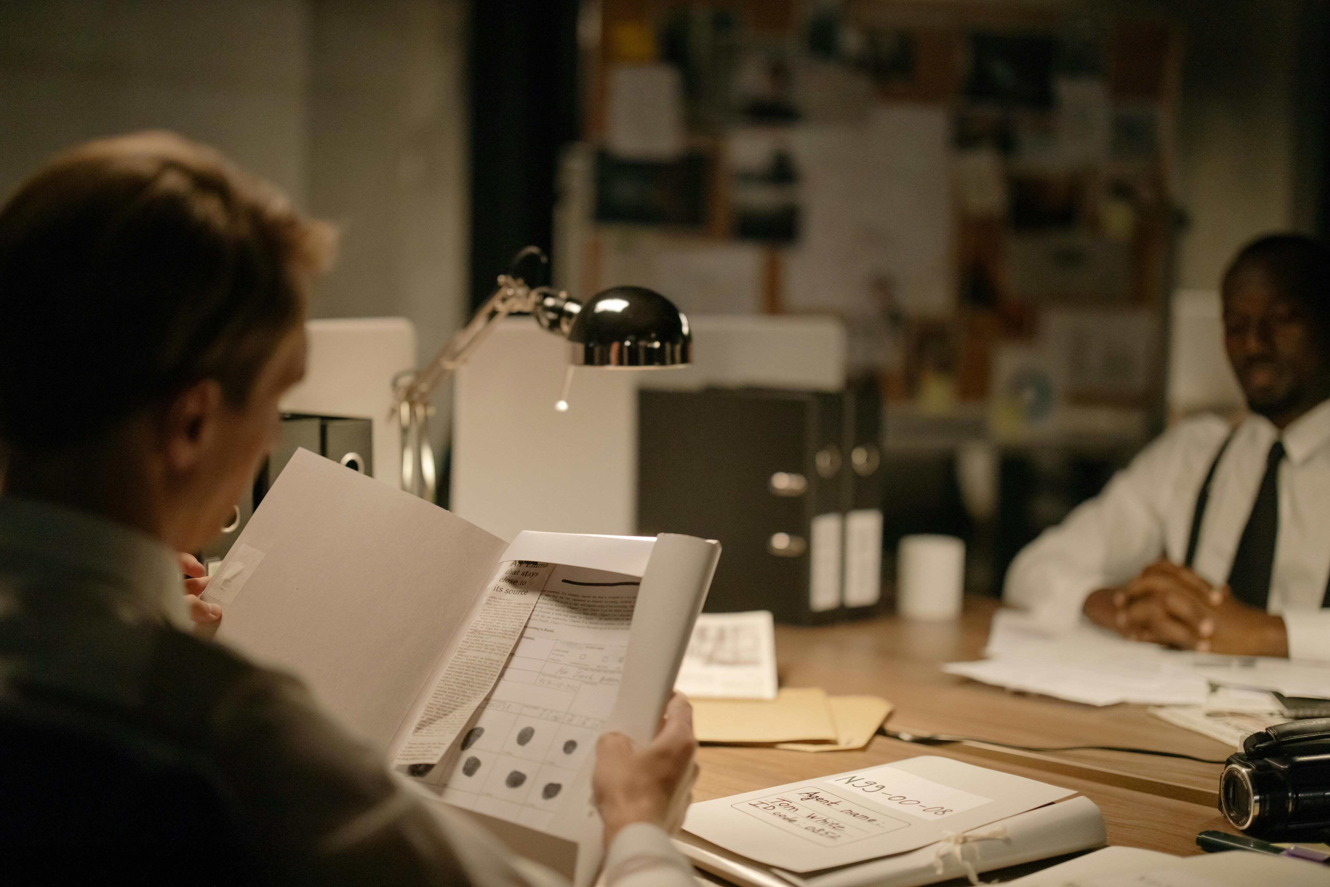 Two men in a dimly lit room going over documents.