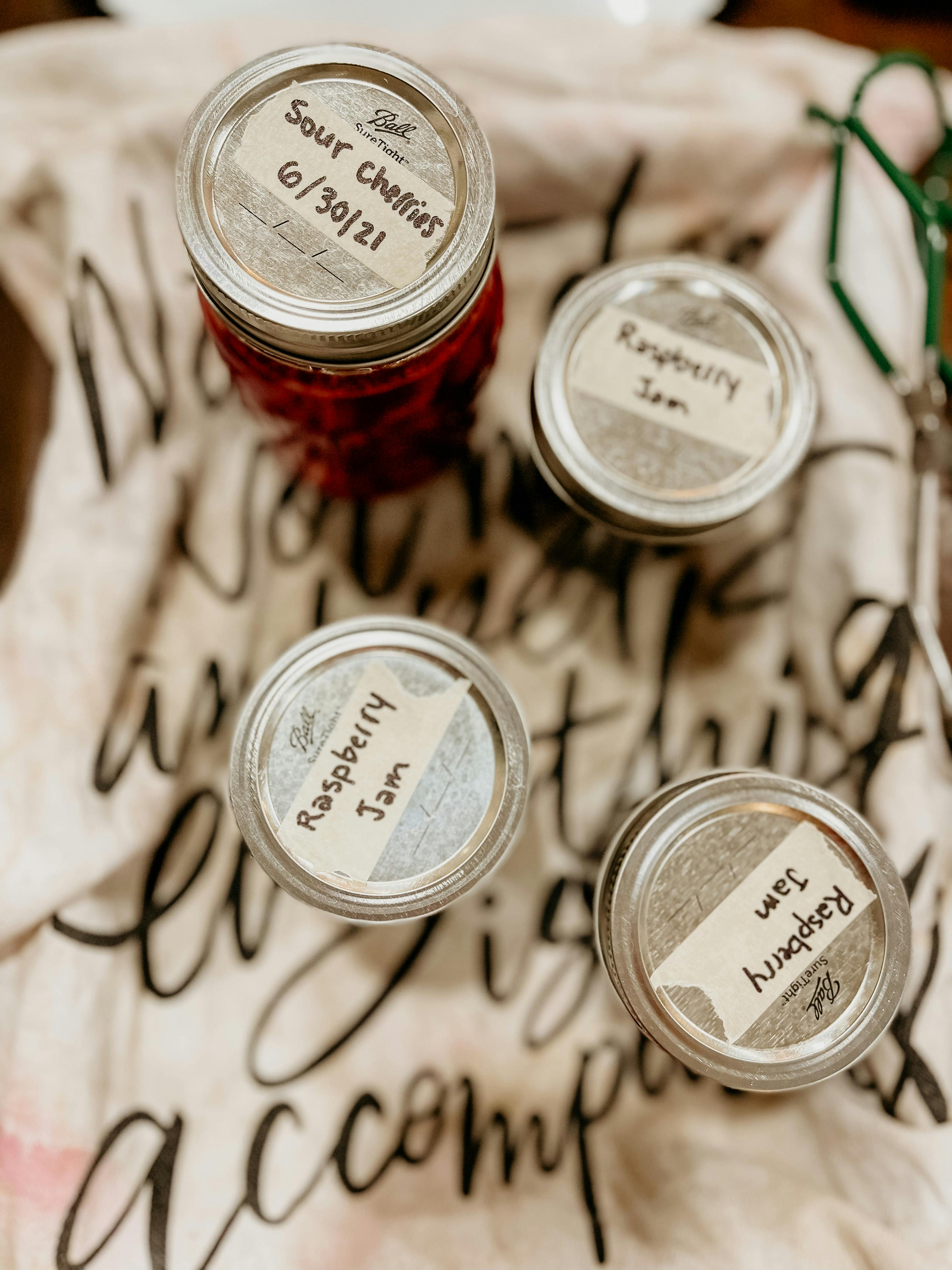 The tops of jars of jam with various flavors on their labels