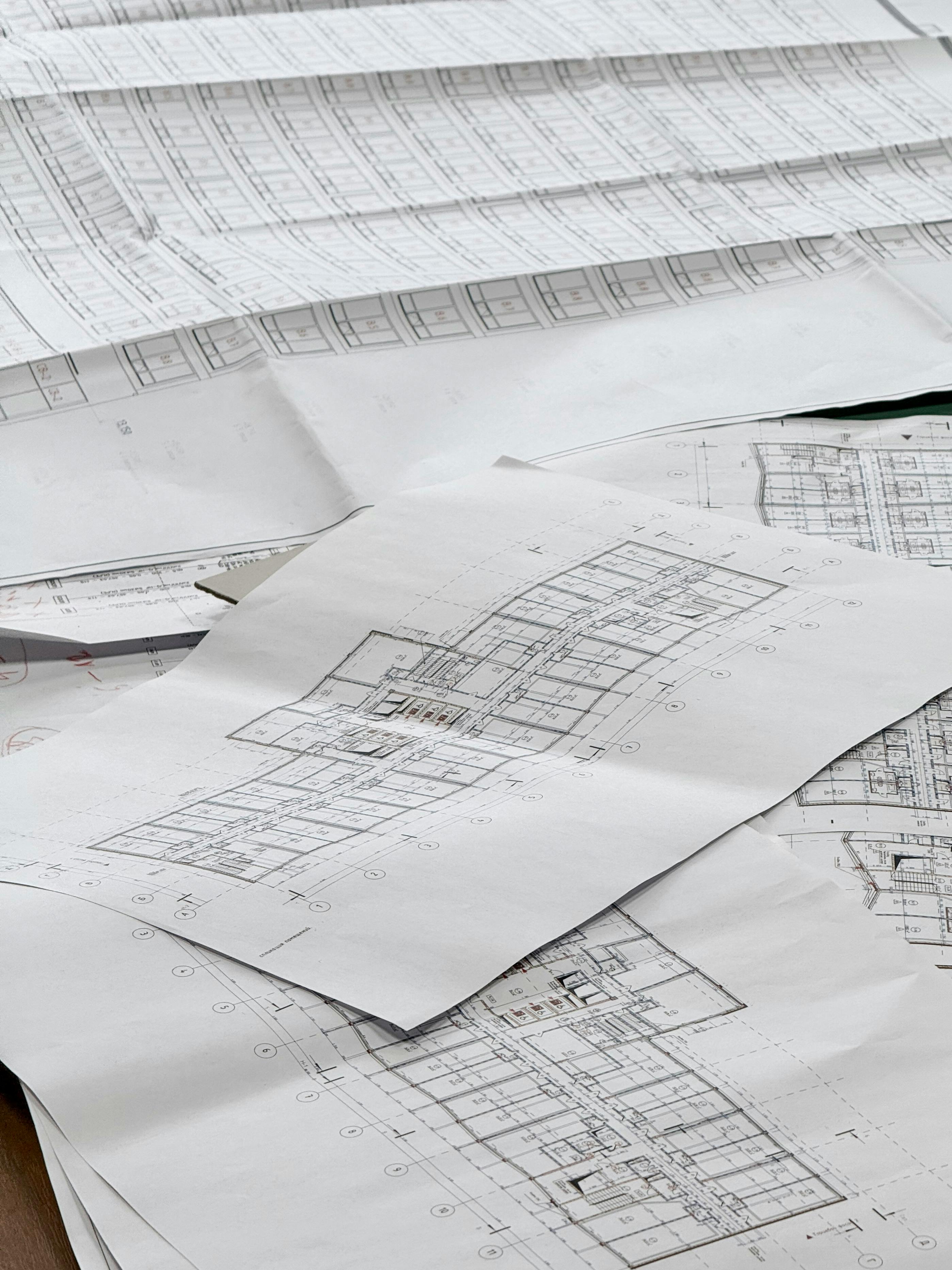A pile of architectural drawings on white paper