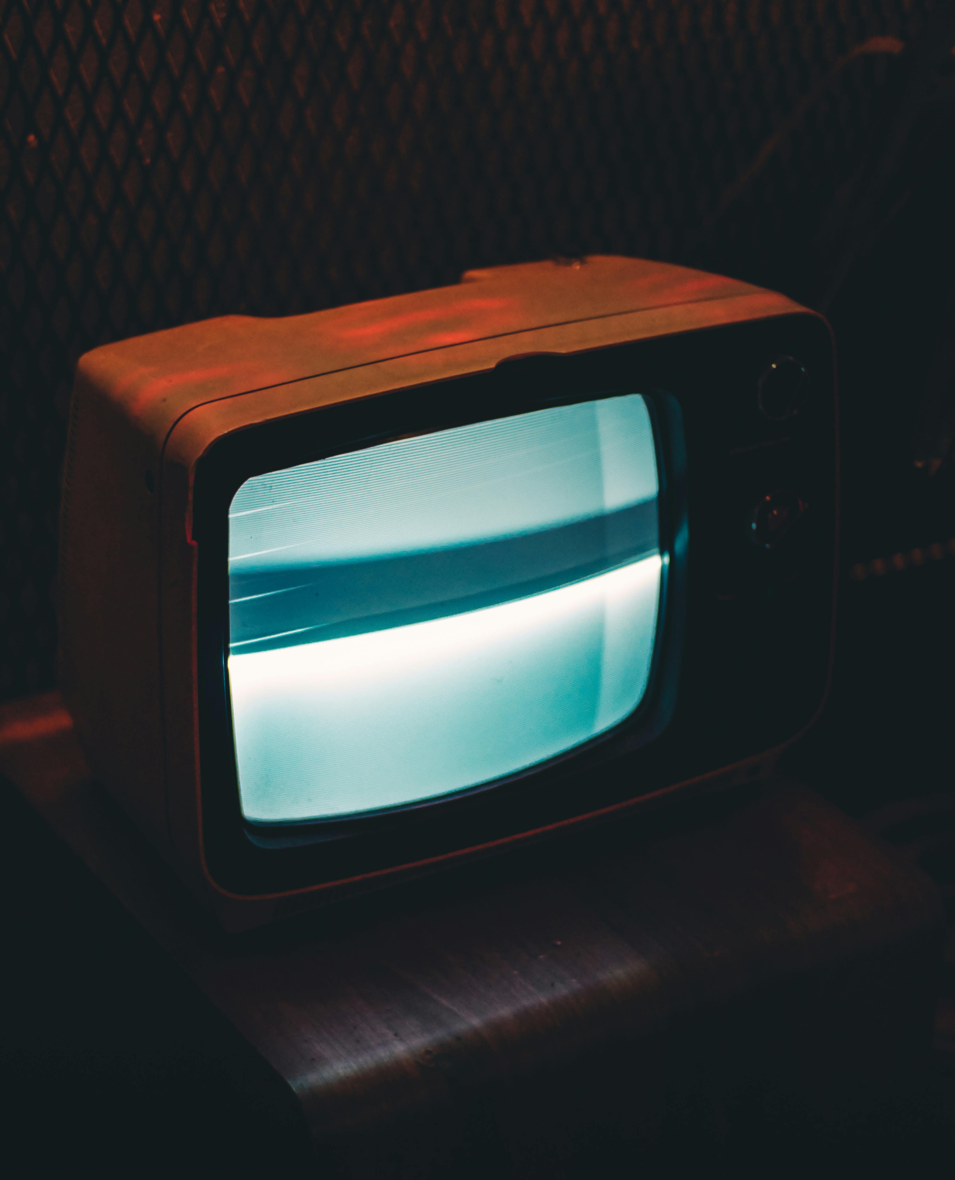 An old TV emitting a blue glow into the dark