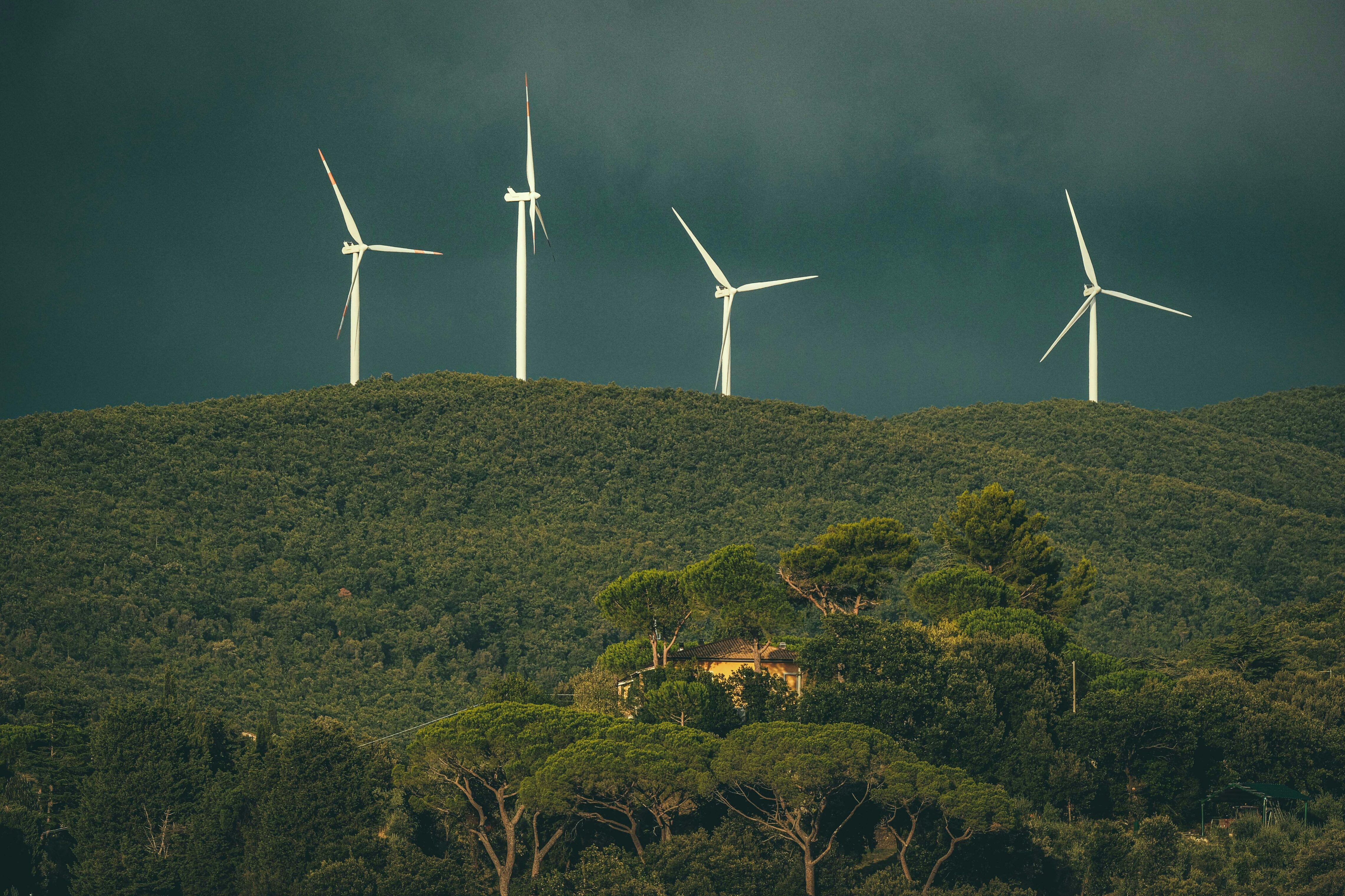 A green mountain, a cloudy day, windmills in the distance
