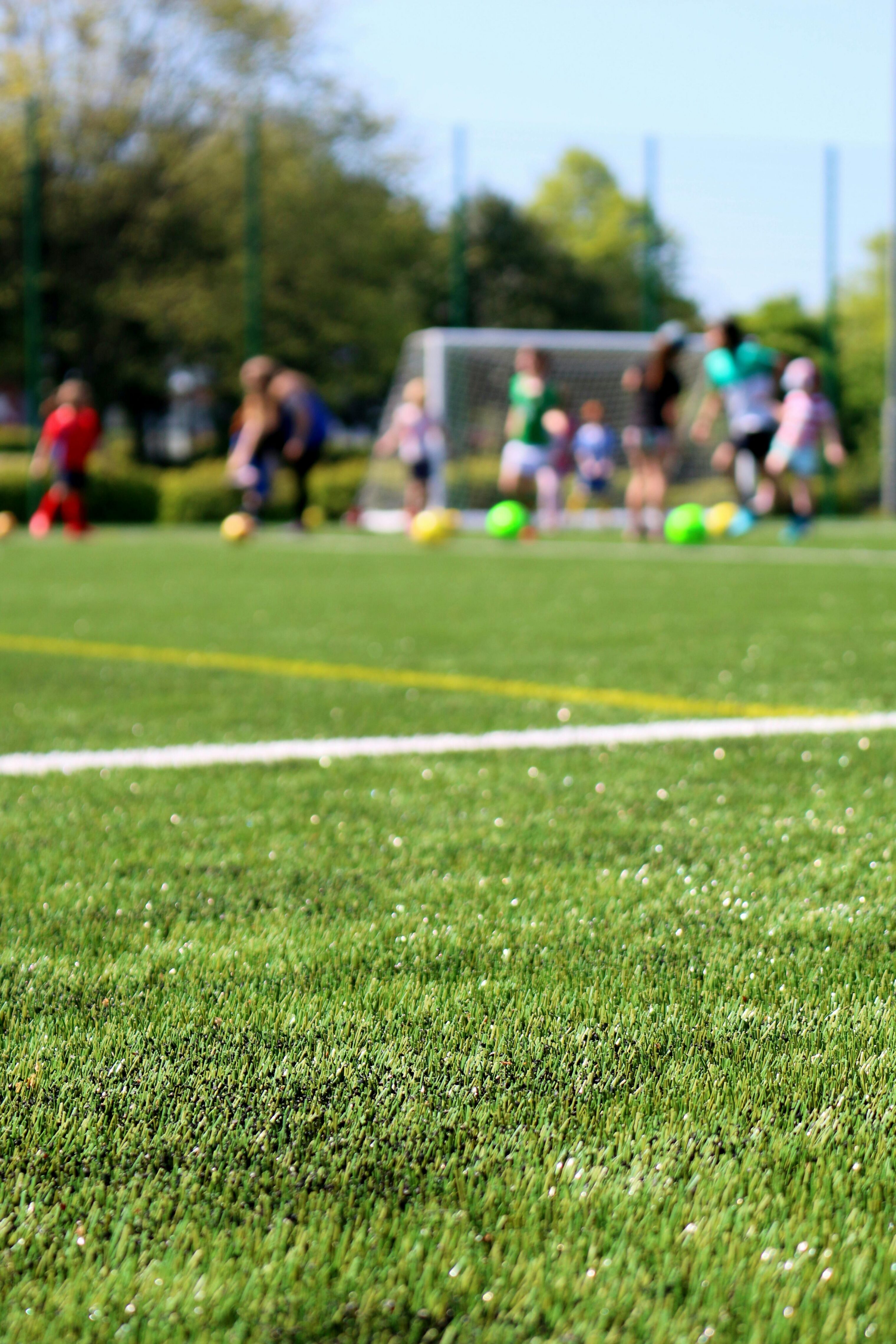 A soccer field with blurred figures in the background