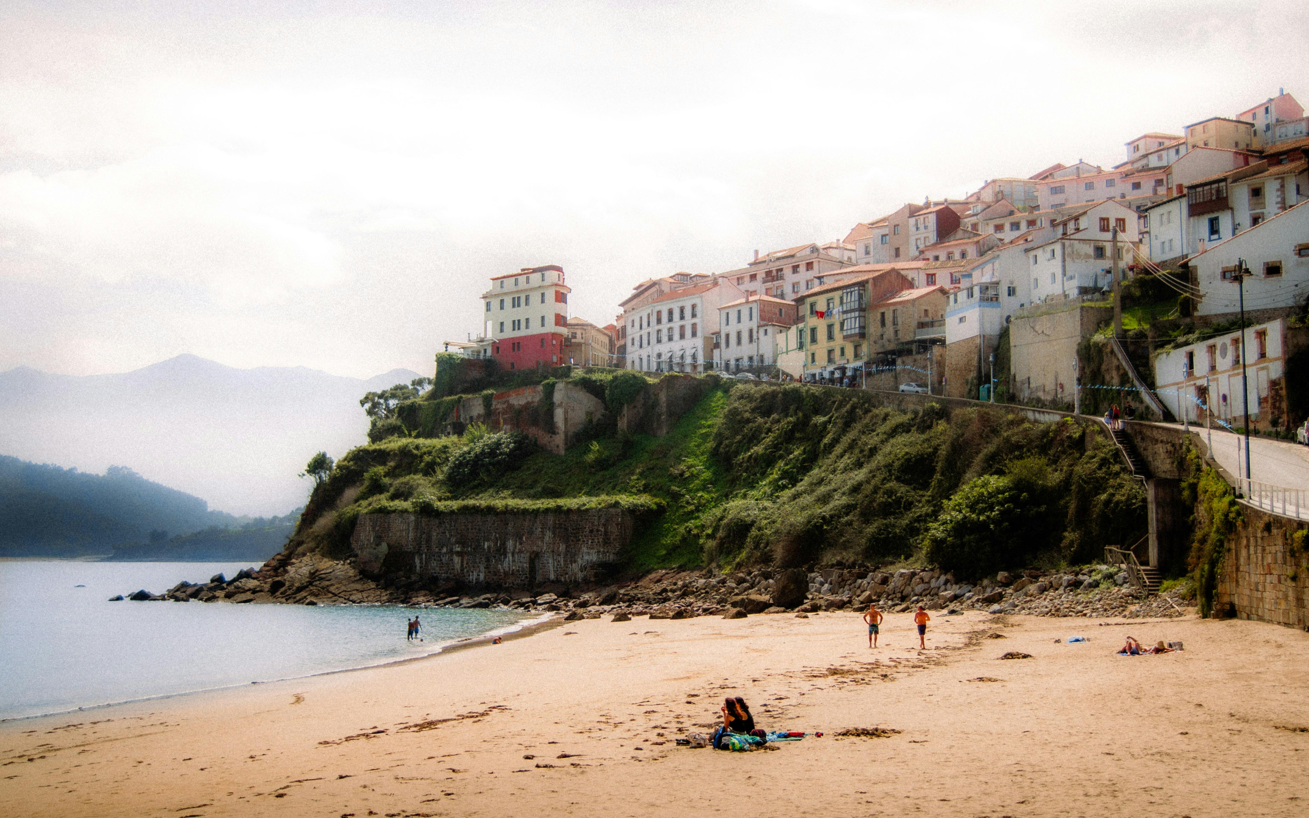 Asturias from the shore; a beach with small, Spanish-style buildings above it