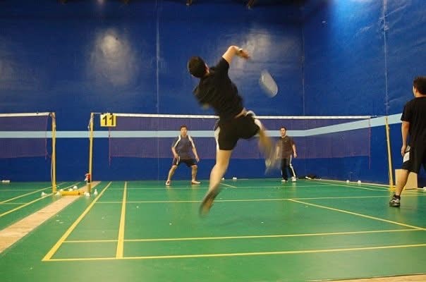 Person from behind playing badminton