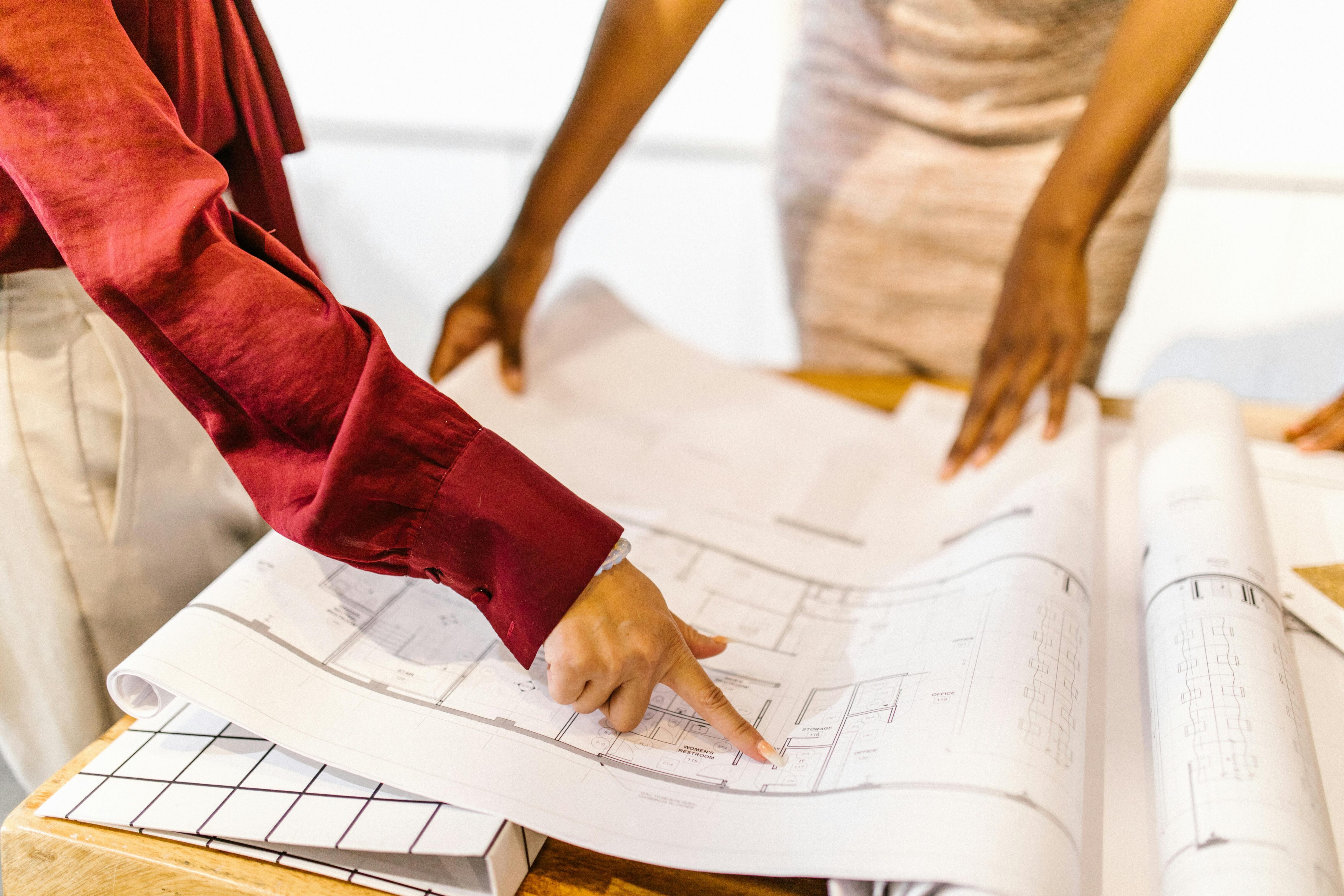People pointing to printed floor plans