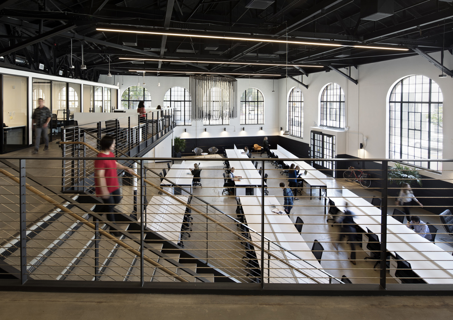 Person walking down stairs in an office in a large warehouse