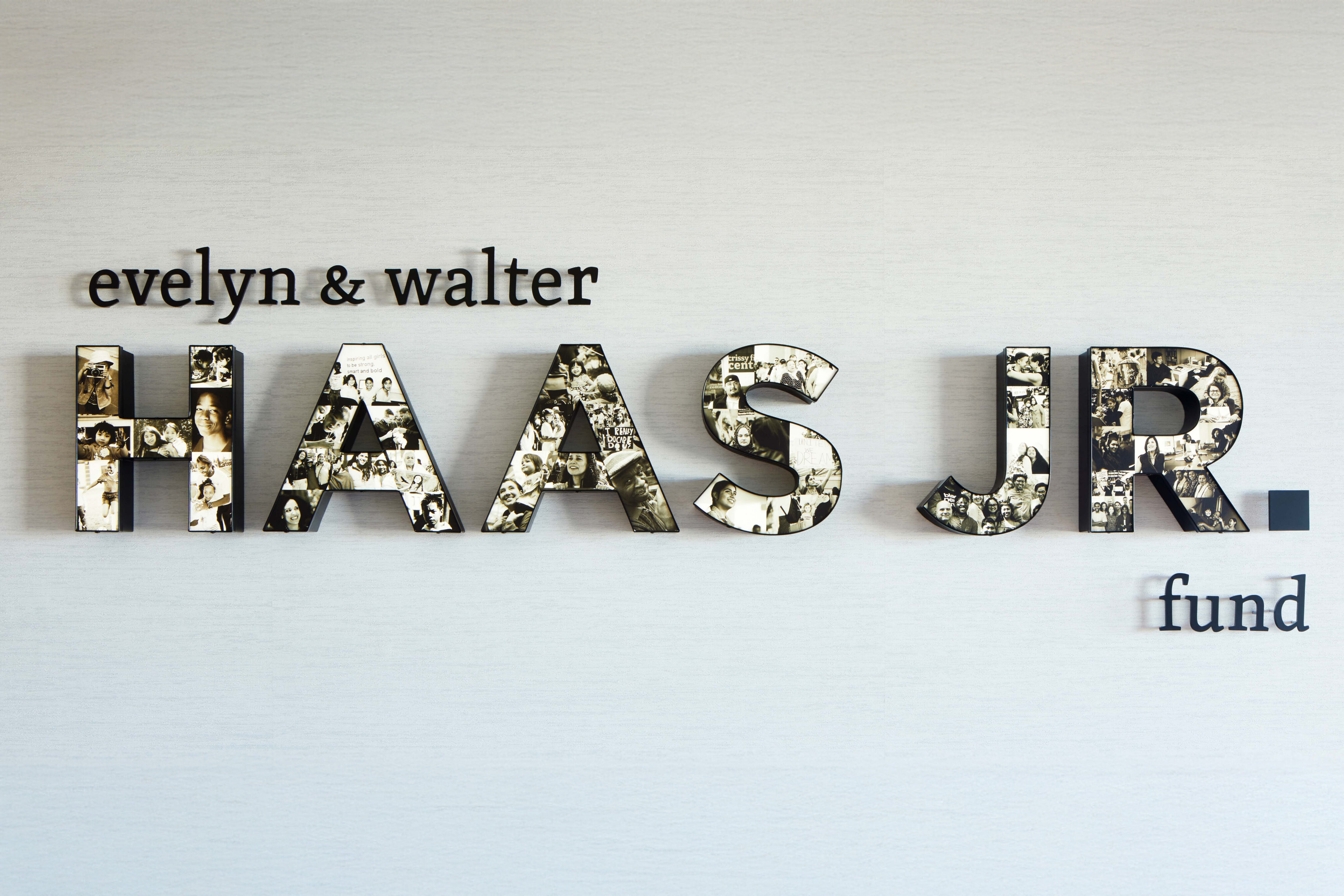 Close-up of the Evelyn & Walter Haas, Jr. Fund wall sign, with the letters filled with a collage of black-and-white photographs.