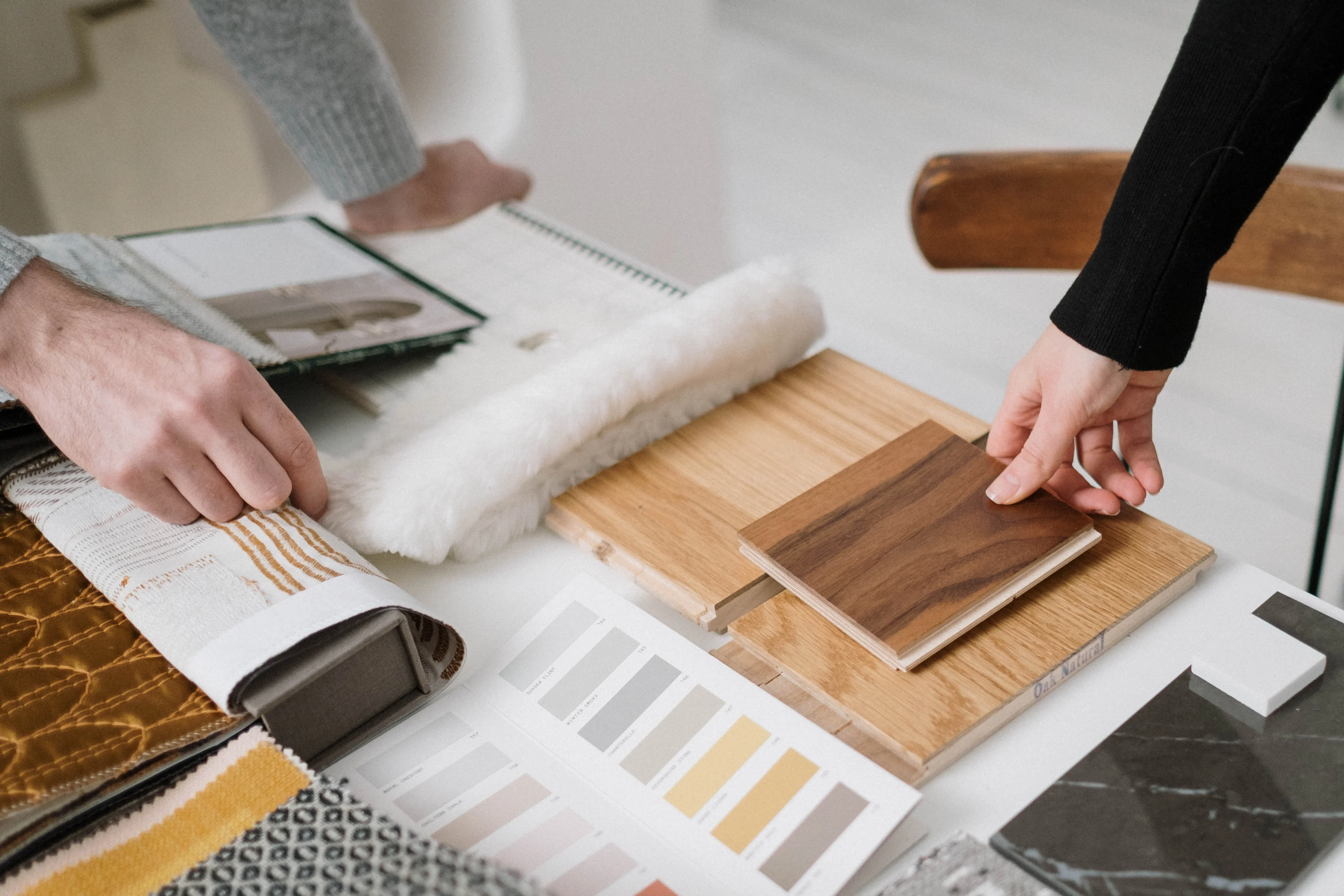 Hands touching materials, tiles, and other interior design-related elements.