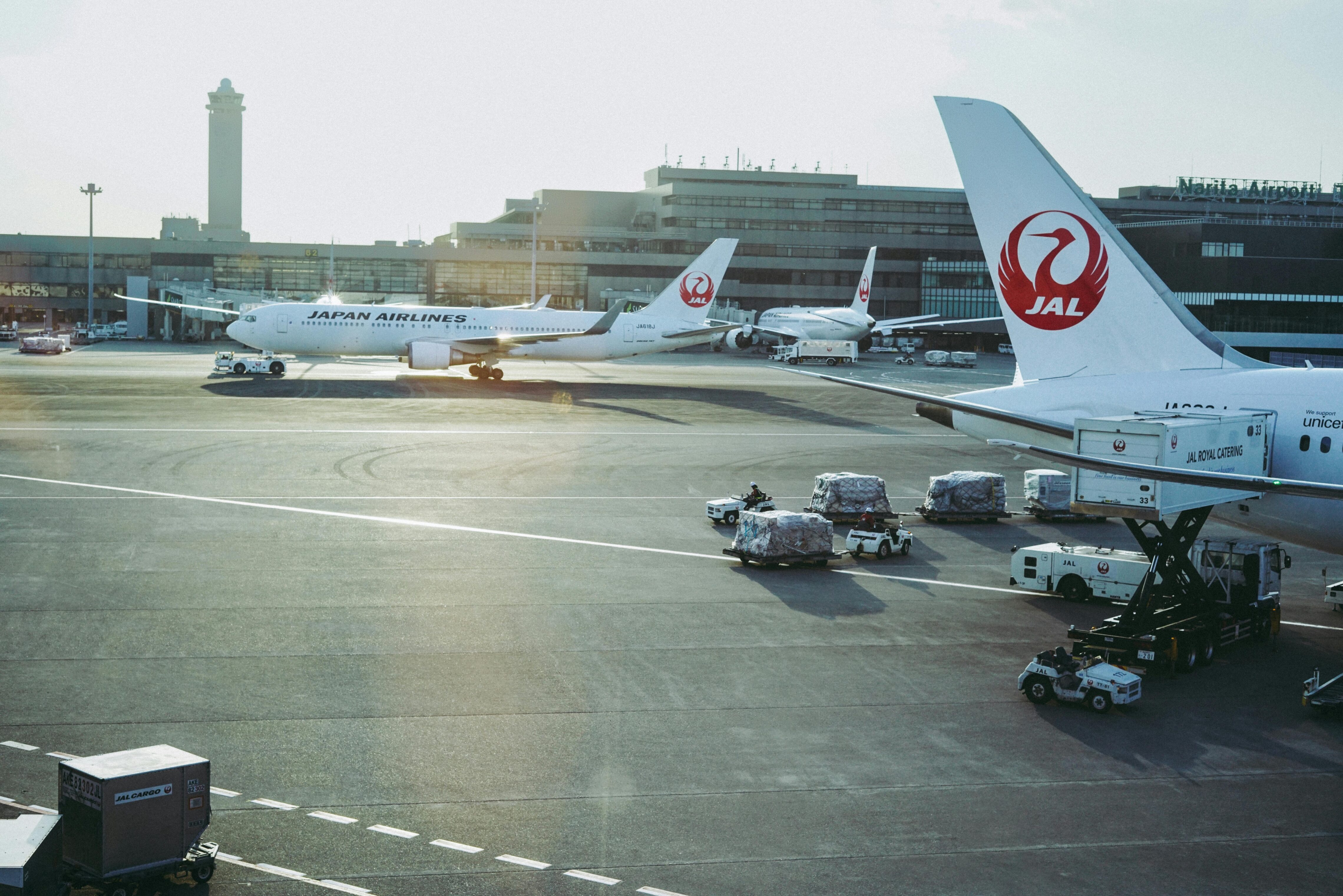 Planes sitting on a tarmac on a sunny day.